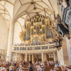 Ein singender Chor steht vor der Ladegastorgel