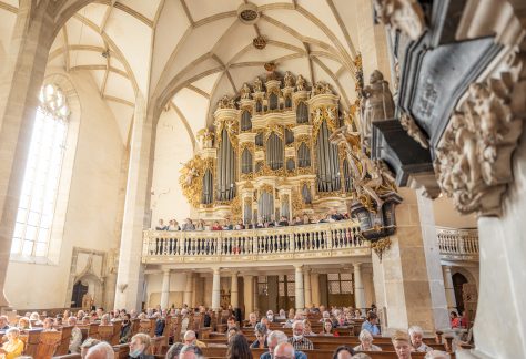 Ein singender Chor steht vor der Ladegastorgel